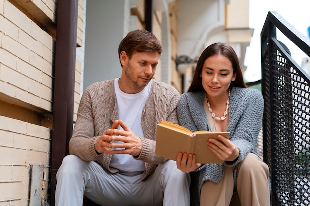 Free photo couple reading outdoors