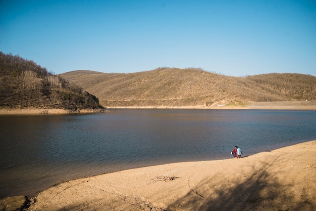 Free photo couple resting by the lake