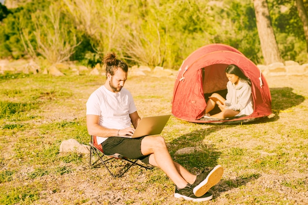 Free photo couple resting in camping and working remotely