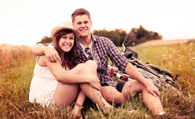 Couple resting on grass after biking