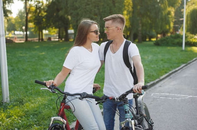 Couple riding bikes in summer city