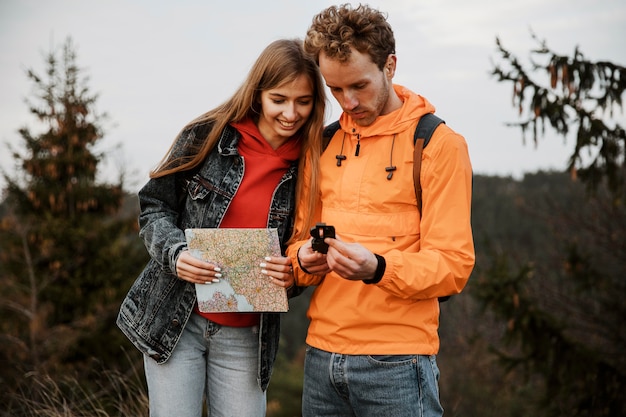 Couple on a road trip together with compass and map