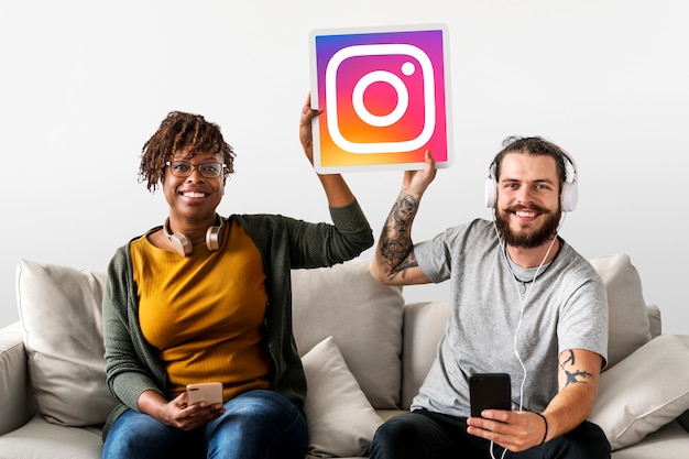 Free Photo couple showing an instagram icon