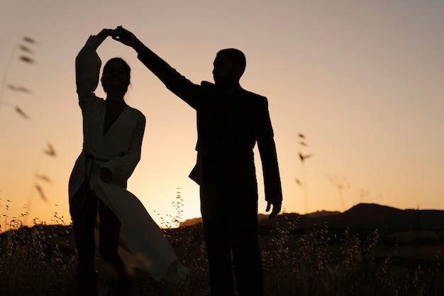 Free photo couple silhouettes dancing in nature full shot