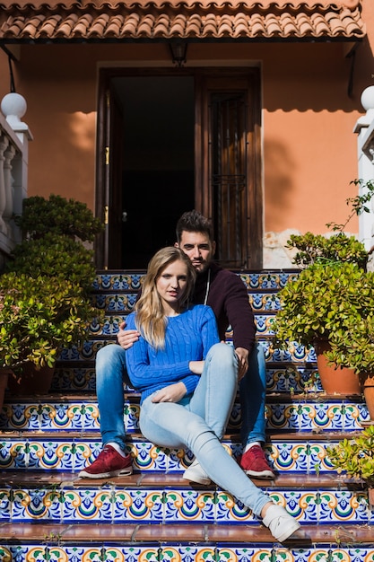 Free Photo couple sitting on beautiful stairs outside