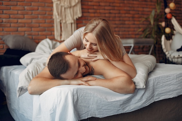 Free photo couple sitting on a bed in a room