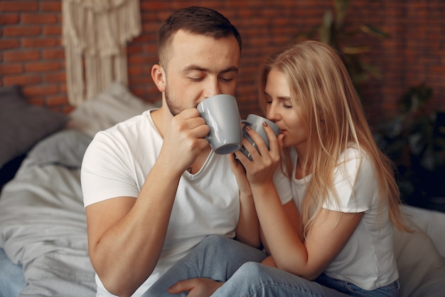 Free photo couple sitting on a bed in a room