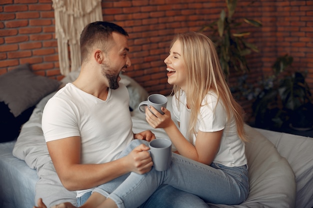 Free photo couple sitting on a bed in a room