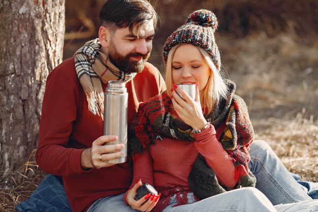 Couple sitting by the tree in a spring forest