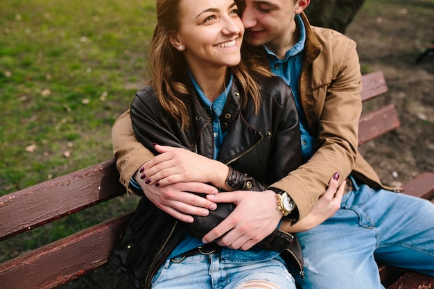 Free photo couple sitting on a park bench