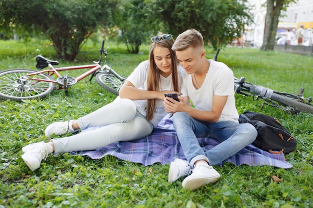 Couple sitting in a park with bicycle