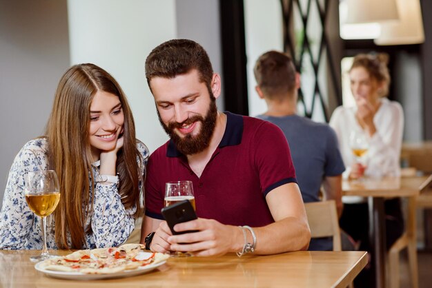 Couple sitting in pizzeria with pizza wine and beer