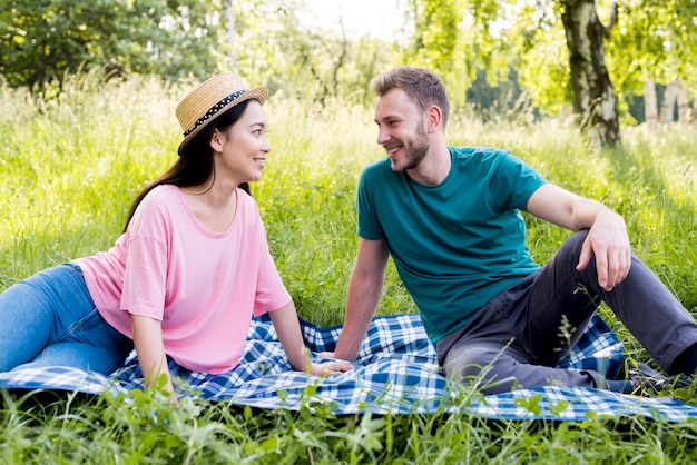 Couple sitting on plaid on picnic