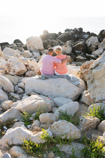 Free Photo couple sitting on rocks back view