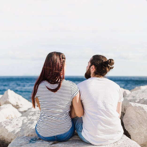 Couple sitting on rocks at the sea