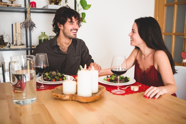 Couple sitting at a table to eat smiling