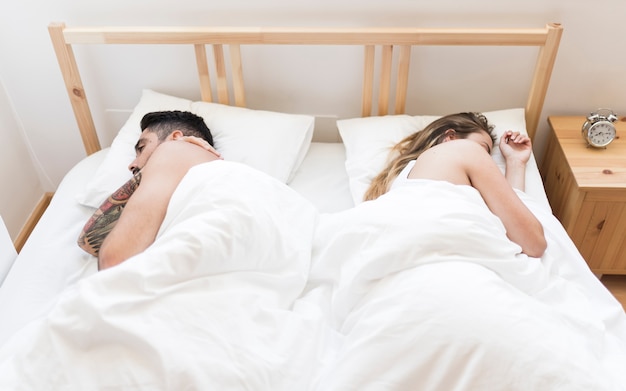 Couple sleeping on bed in bedroom