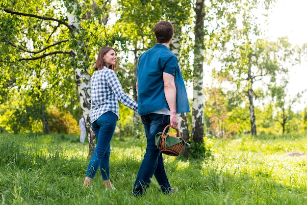 Free photo couple smiling while going for picnic in forest