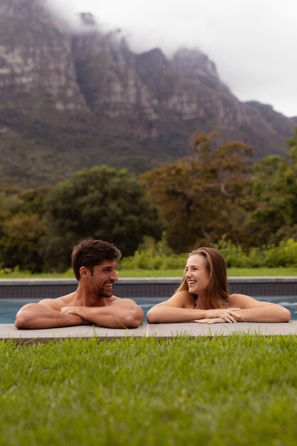 Couple standing at the edgef of swimming pool 