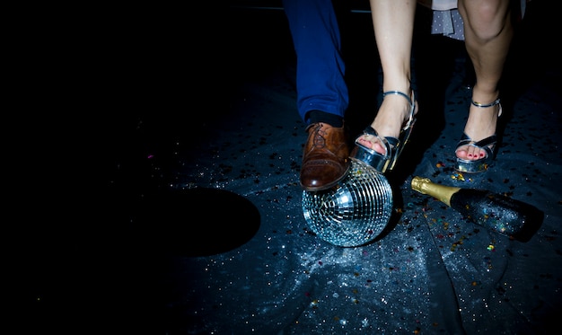 Free photo couple standing on floor with disco ball