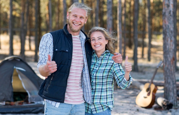 Couple standing in front of tent and blurred guitar