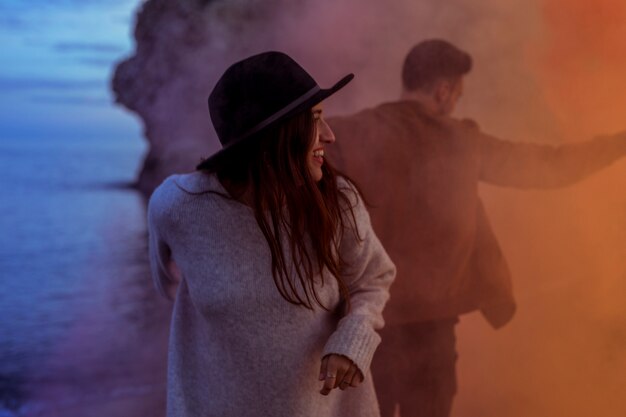 Couple standing in smoke on sea shore