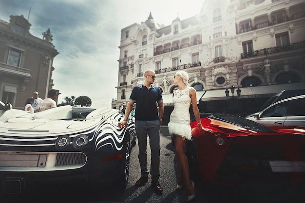 Free photo couple stands between bugatti and lamborgini somewhere in monte carlo