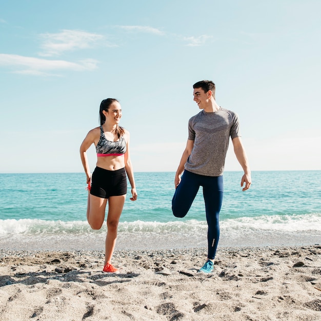 Free photo couple stretching at the beach