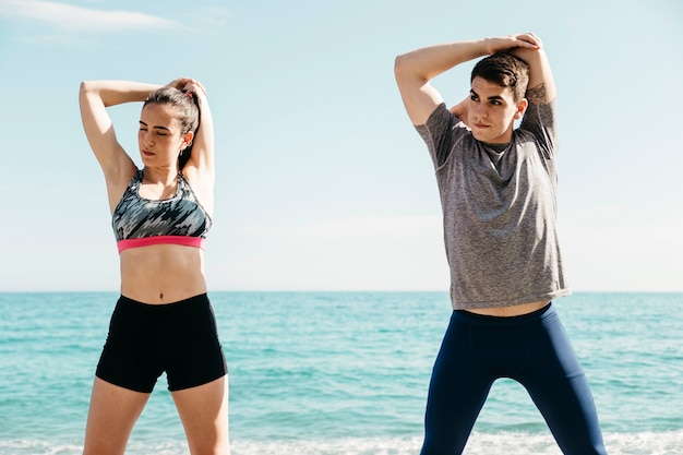 Free photo couple stretching at the beach