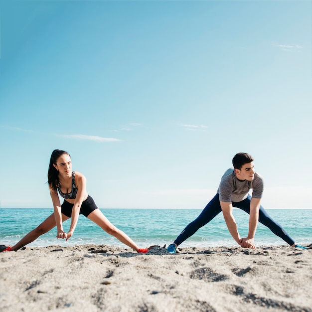 Free Photo couple stretching at the beach