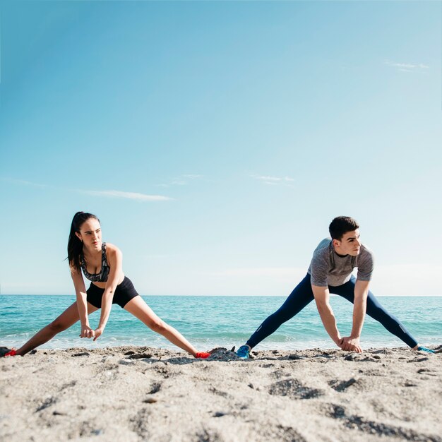 Couple stretching at the beach