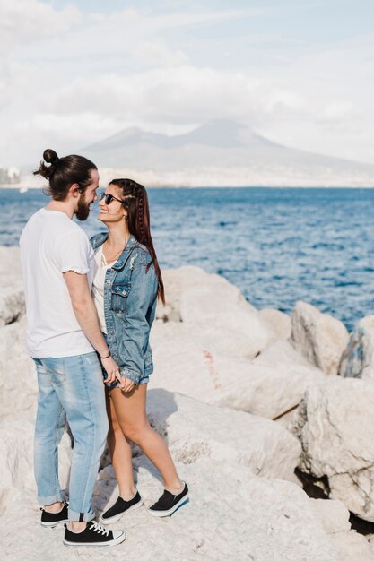 Couple and summer concept on rocks by the sea