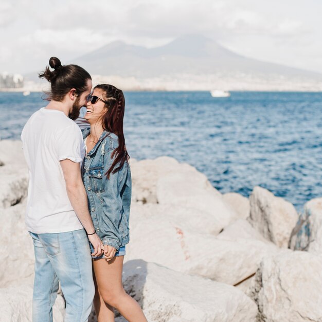 Couple and summer concept on rocks by the sea