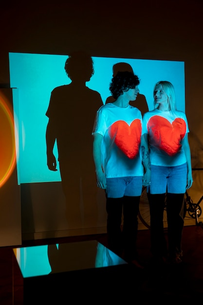 Free photo couple taking photos in the light of movie projector