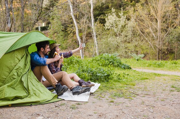 Couple taking selfie near tent