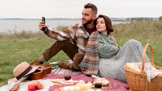 Couple taking selfie at picnic