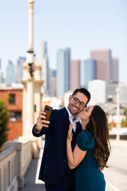 Couple taking selfie together outdoors with engagement ring