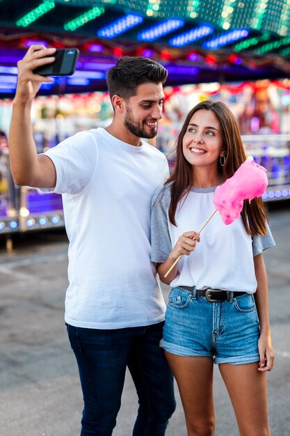 Couple taking selfie with pink cotton candy