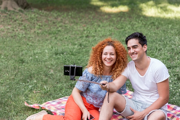 Free photo couple taking selfies with smart phone on picnic date