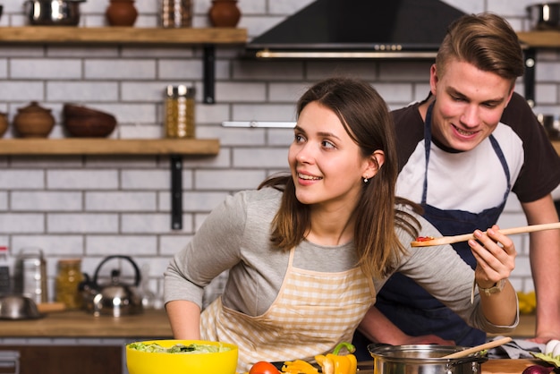 Free photo couple tasting cooked meal