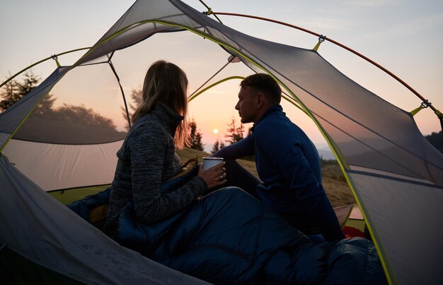 Couple of tourists resting in tent outdoors