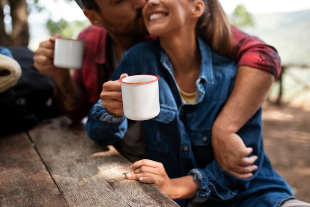 Free Photo couple traveling in nature and enjoying a beverage