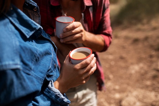 Free photo couple traveling in nature and enjoying a beverage