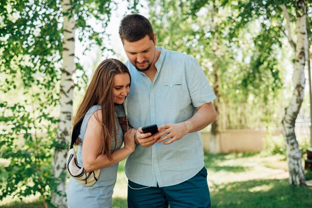 Couple using smartphone in birch forest