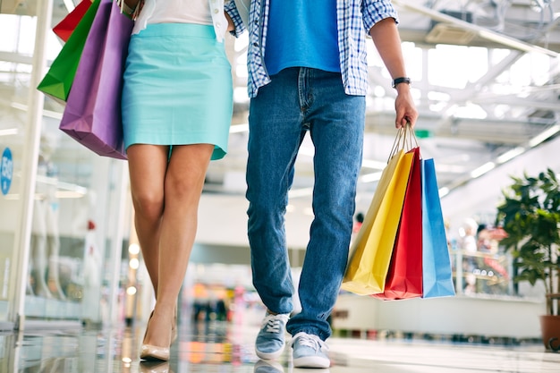 Couple walking along mall with shopping bags