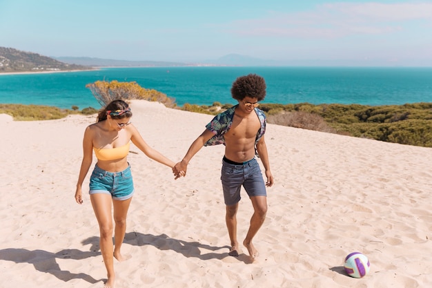 Couple walking on beach and holding hands