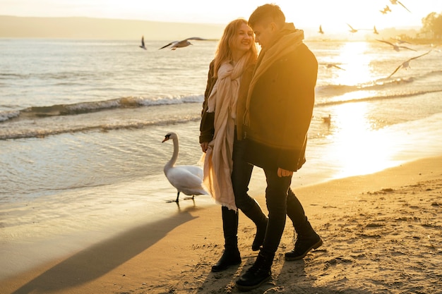 Free photo couple walking on the beach in winter