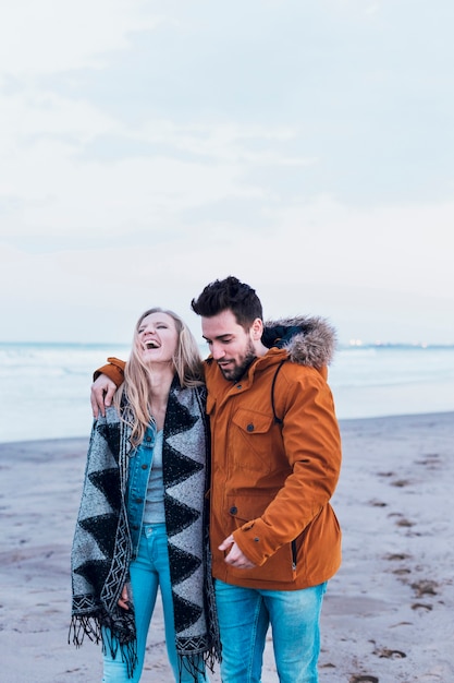 Couple in warm clothes on beach