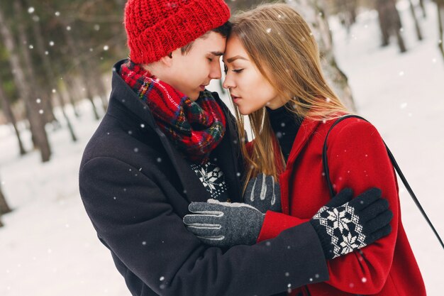 Couple in winter clothes hugging on a snowy day