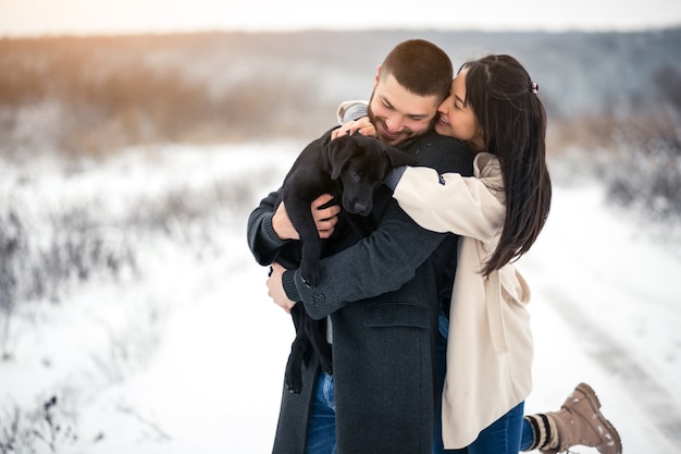 Couple in winter in the street with dog